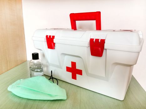 Home first aid kit with a respiratory face mask and disinfectant.Texture or background