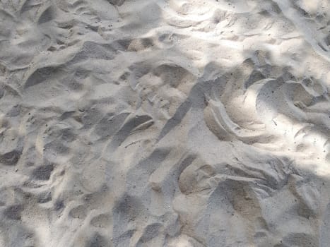 Natural background of sand texture with irregularities and depressions.