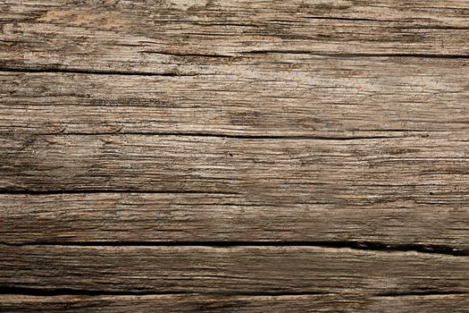 The surface of the old wood, split by time, is brown. Texture or background