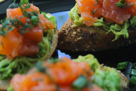 French bread slices with slices of red fish and greens