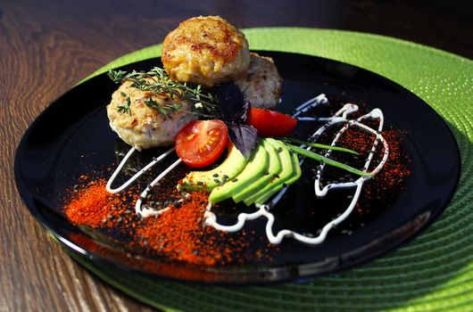 Sliced zucchini with cutlets is beautifully decorated with mayonnaise and herbs