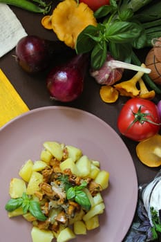 Fried chanterelles with potatoes and herbs on a plate.Texture or background