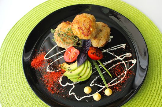 Fried cutlets are decorated with mayonnaise with herbs and cherry tomatoes