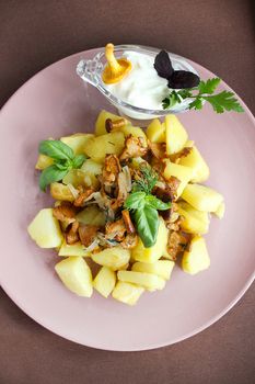 Close-up of a dish of fried chanterelles with potatoes in a rustic way with greens.Texture or background