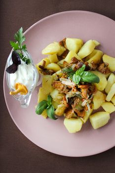 On a plate fried chanterelles with onions and homemade potatoes.Texture or background