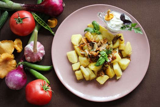 Hot dishes fried potatoes with chanterelles and vegetables close up