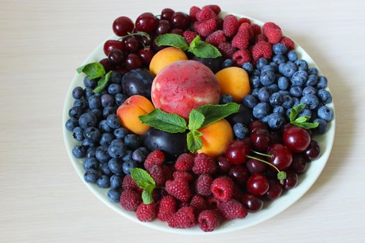 On the table on a white plate berry mix.Texture or background