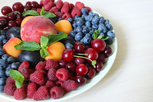 Summer mix of berries on a white plate .Texture or background