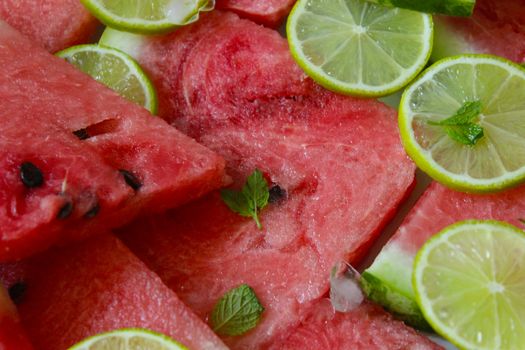 Slices of fresh watermelon close-up with lime and mint.Texture or background