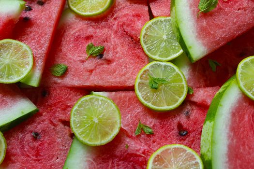 Watermelon slices close-up with lime slices and mint leaves.Texture or background
