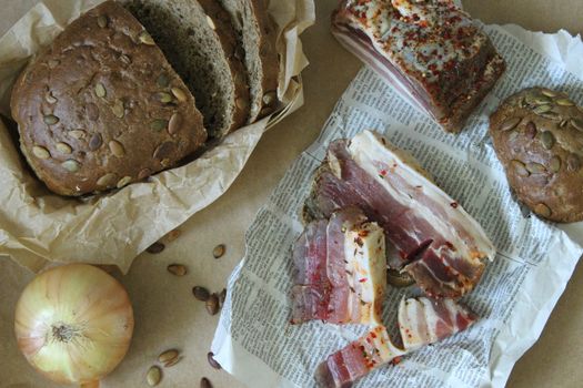 Sliced bread with bacon and onions are on the table.Texture or background