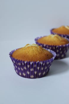 Vanilla three cupcakes in a blue wrapper .Texture or background