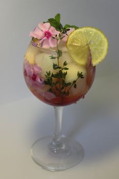 Refreshing homemade lemon juice with ice cubes and decorated with flowers
