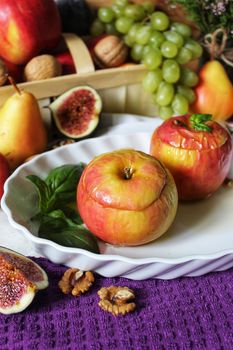 Fruit still life baked apples in syrup on a white plate with a mint leaf.Texture or background