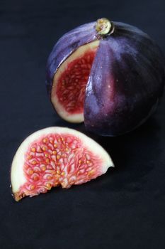 A slice of purple figs on a dark background .Texture or background
