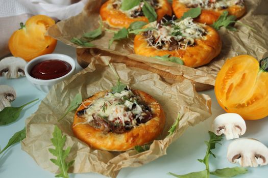 Rustic pastries with mushrooms and meat and decorated with cheese close-up.Texture or background