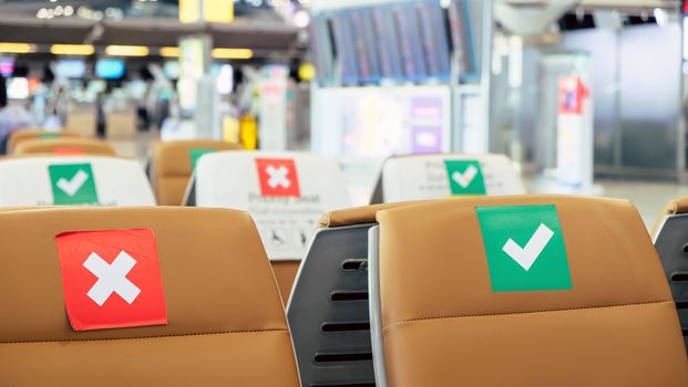 Social distancing, Rows of empty chairs in an airport's departure area marked with symbols regarding social distancing protocol to prevent the spreading of novel corona virus, COVID-19 in Thailand