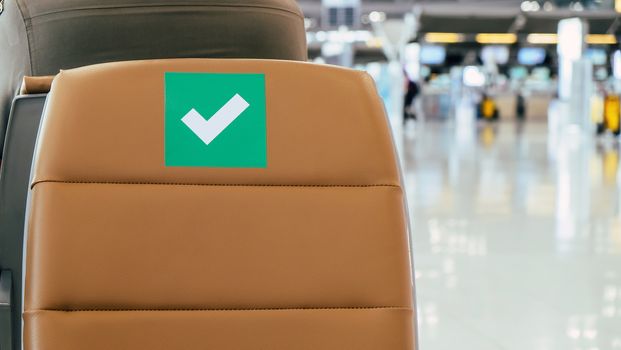 Social distancing, Rows of empty chairs in an airport's departure area marked with symbols regarding social distancing protocol to prevent the spreading of novel corona virus, COVID-19 in Thailand