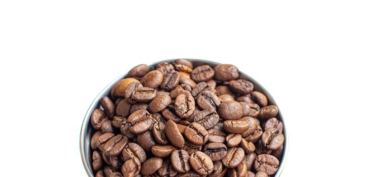A lot of coffee beans in a metal coffee grinder on a white background. The view from the top. Isolated