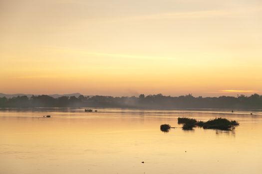 Muong Khong Laos 1/12/2012 Mekong river at dawn with golden sun and traditional fishing boats with nets . High quality photo