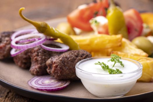 cevapcici on a plate with french fries