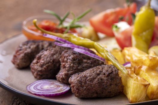cevapcici on a plate with french fries