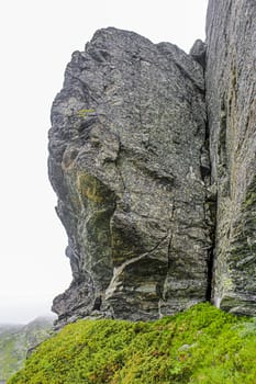 Big rocks and cliffs with fog and clouds on Veslehødn Veslehorn mountain in Hemsedal, Norway.