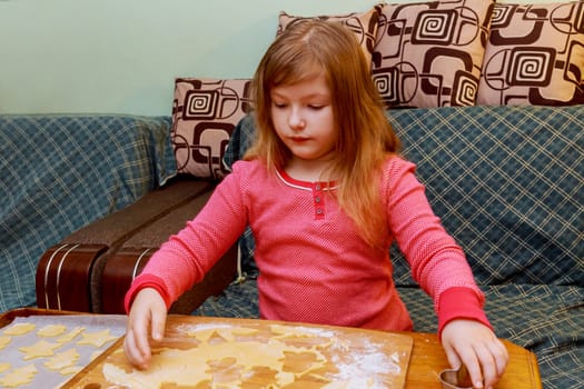 Sweet little cute girl is learning how to make a cake, in the home Happy little girl child cooking