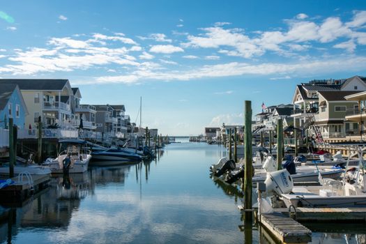 A View of a Canal With Boats and Homes on Each Side on a Clear Blue Sky With Gorgeous Clouds in Wildwood New Jersey