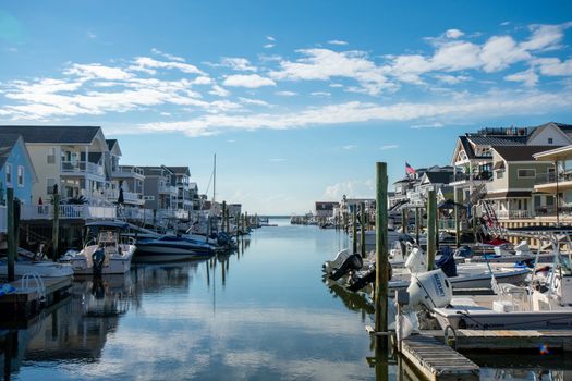 A View of a Canal With Boats and Homes on Each Side on a Clear Blue Sky With Gorgeous Clouds in Wildwood New Jersey