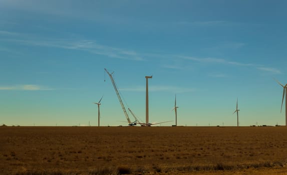 Electric wind turbine windmill installation wind turbine with blue sky background.