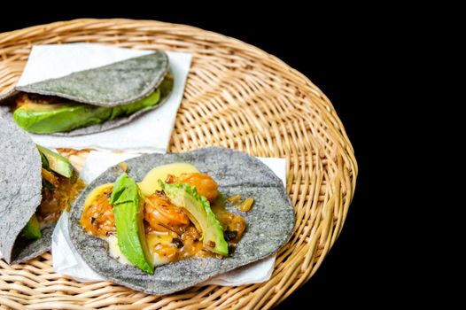 Tacos Gobernador (governors tacos), shrimp tacos cooked with spices and cheese, served on blue corn tortillas with avocado.