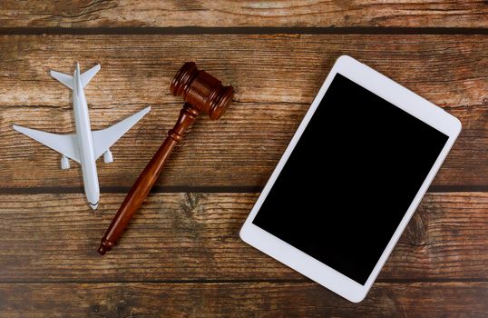 Judge traveling concept planning airplane in wooden judges gavel with digital tablet on airplane model plane