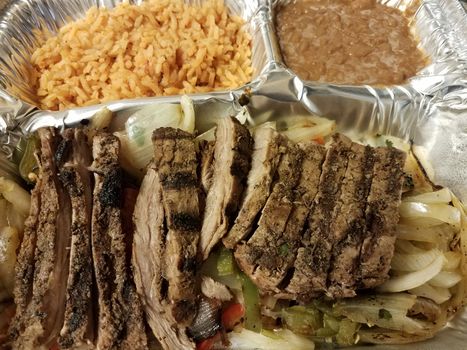 steak fajita meat with rice and beans in metal container or tray