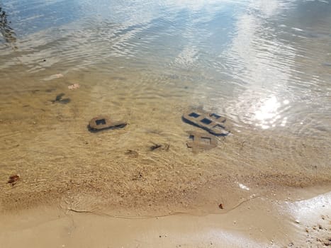 cement blocks in river or lake water at shore with sand