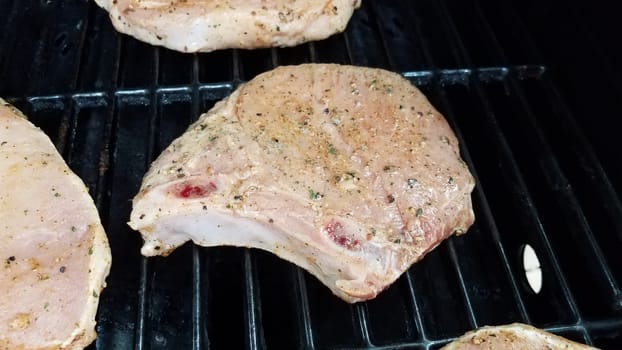seasoned pork chop meat cooking on barbecue grill