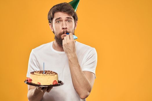 A bearded man with a cake and in a cap celebrating his birthday. High quality photo