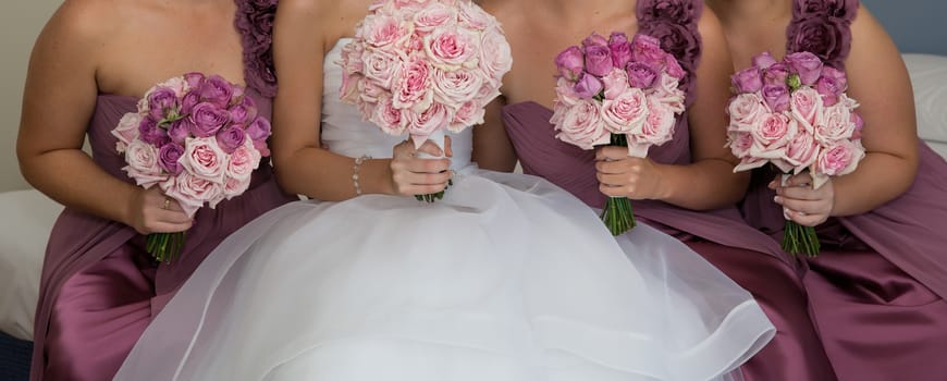 A bride with her bridesmaids all holding their bouquets and posing prior to the wedding ceremony