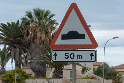 Traffic rules, speed bump road sign with distance sign. Stock photo
