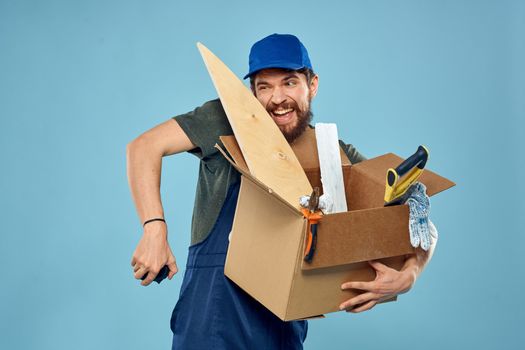 Worker man in uniform box tools construction blue background. High quality photo