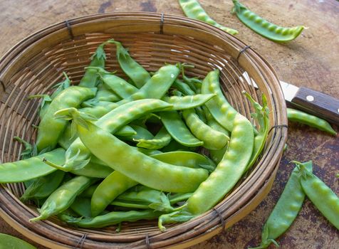 Peas on wooden cutting board to prepare the food.