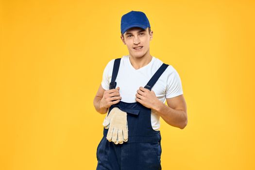 Man in working uniform emotions rendering service delivery service yellow background. High quality photo