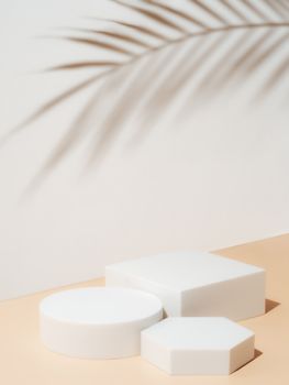 Set of different geometric shapes as empty pedestals on pastel background. Mockup for cosmetic, packaging, product presentation with tropical leaf shadow.Natural beauty podium in hard light. Vertical