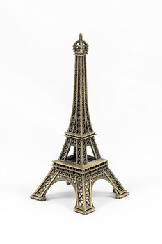 Close up shot of a bronze miniature model of the Eiffel Tower isolated on a white background