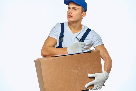 Man worker with box in hands delivery loading service work light background. High quality photo