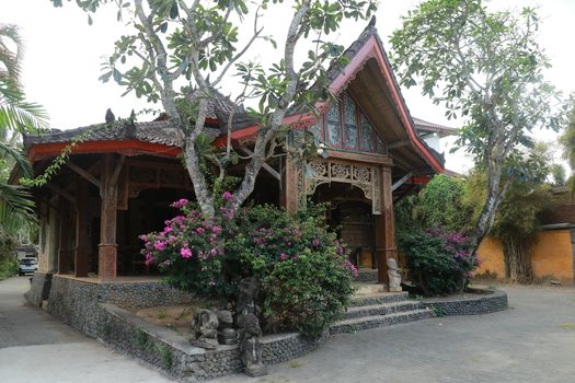 One of the traditional houses that is still preserved in the village. Traditional wooden house in a tropical garden on Lombok island, Indonesia.