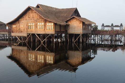 Inle Lake Myanmar 12/16/2015 Shwe Inn Tha Floating Resort. Beautiful traditional buildings on stilts on the lake photograped early morning with clear reflections. High quality photo