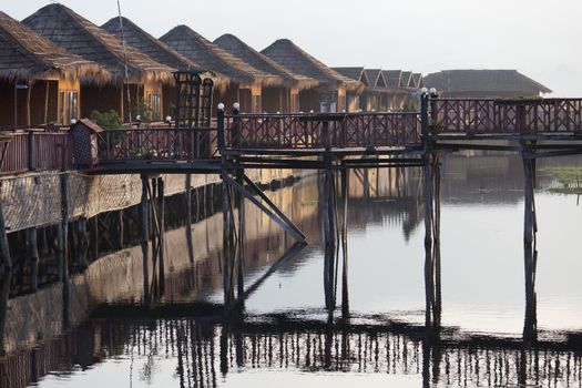Inle Lake Myanmar 12/16/2015 Shwe Inn Tha Floating Resort. Beautiful traditional buildings on stilts on the lake photograped early morning with clear reflections. High quality photo