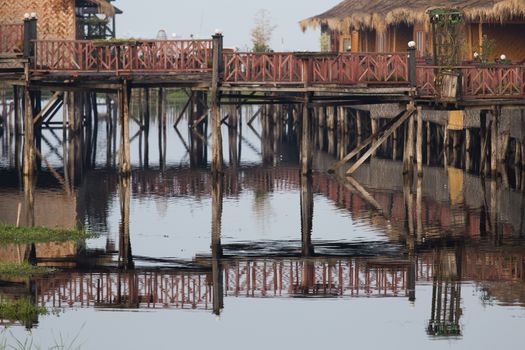 Inle Lake Myanmar 12/16/2015 Shwe Inn Tha Floating Resort. Beautiful traditional buildings on stilts on the lake photograped early morning with clear reflections. High quality photo