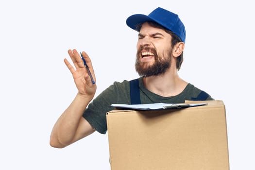 Working male courier with box in hand documents delivery service light background. High quality photo
